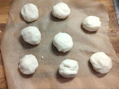 Acht Teigkugeln auf Backpapier