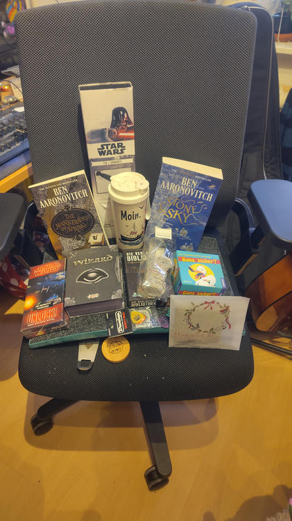 Ein Bild der schwedischen Torte in der Mitte eines Esstisches, mit drei Stücken auf Tellern. Auf einem davon gibt eine Person (nur ihre Hände sind zu sehen) die Vanillesauce darauf.