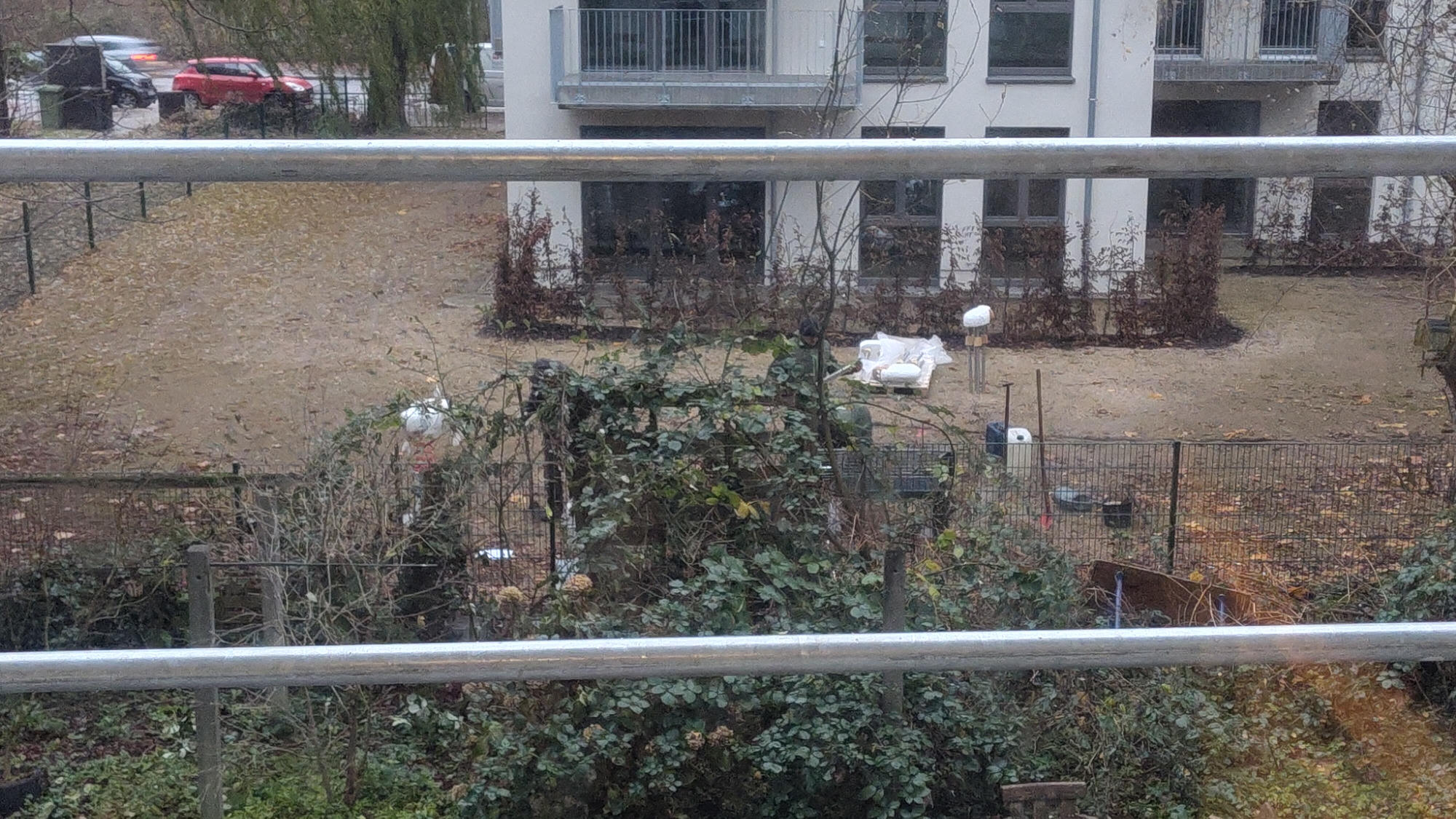 Entferntes Bild von einigen kleinen Spielgeräten, die noch in Folie verpackt vor einem Haus stehen.